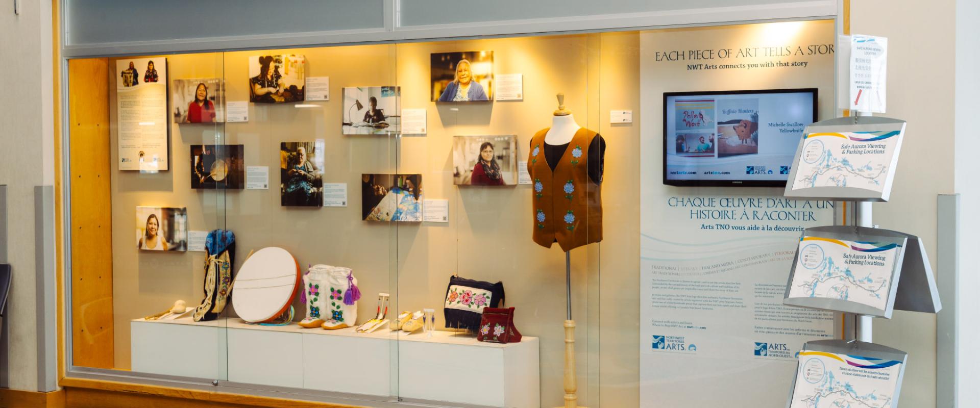 The image features a display case filled with various northern art.