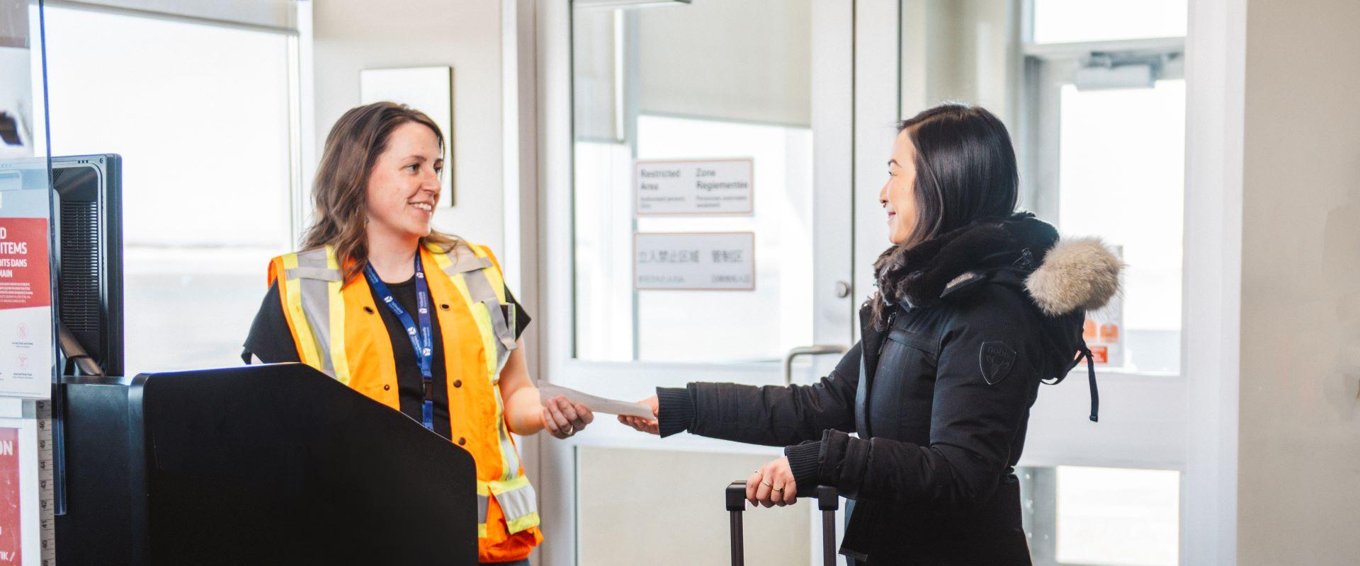 Image shows a passagering receiving boarding pass.